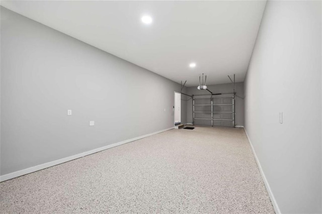 garage with a garage door opener, recessed lighting, and baseboards