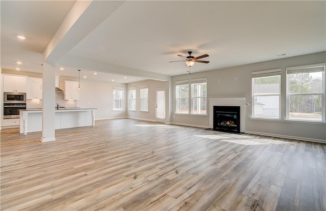 512 Dolce Rd, Locust Grove, GA 30248 - unfurnished living room featuring recessed lighting, ceiling fan, baseboards, a fireplace with flush hearth, and light wood-style floors