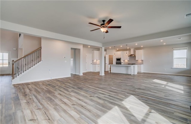 512 Dolce Rd, Locust Grove, GA 30248 - unfurnished living room with light wood-style flooring, a wealth of natural light, and a ceiling fan