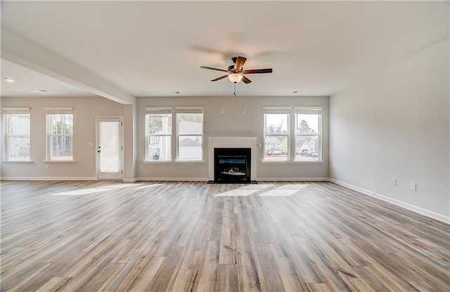 512 Dolce Rd, Locust Grove, GA 30248 - unfurnished living room featuring baseboards, a fireplace with flush hearth, ceiling fan, and wood finished floors