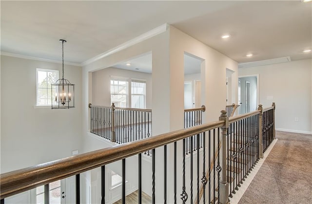 512 Dolce Rd, Locust Grove, GA 30248 - hall with an upstairs landing, crown molding, an inviting chandelier, carpet floors, and baseboards