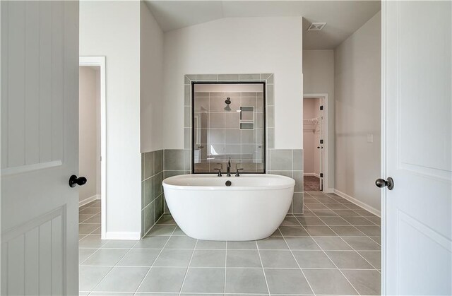 512 Dolce Rd, Locust Grove, GA 30248 - full bathroom with visible vents, tile patterned floors, a spacious closet, tiled shower, and a freestanding tub