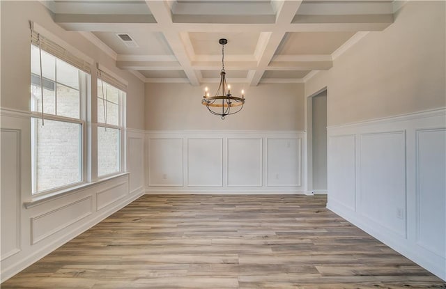 512 Dolce Rd, Locust Grove, GA 30248 - unfurnished dining area featuring an inviting chandelier, light wood-type flooring, a decorative wall, and beamed ceiling