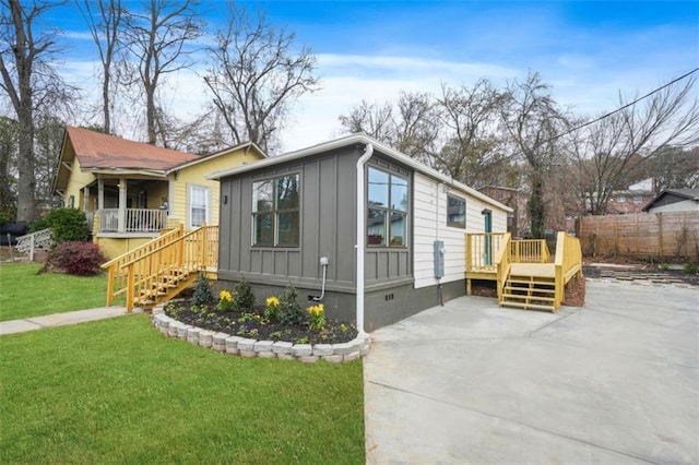 view of front facade featuring a wooden deck and a front lawn