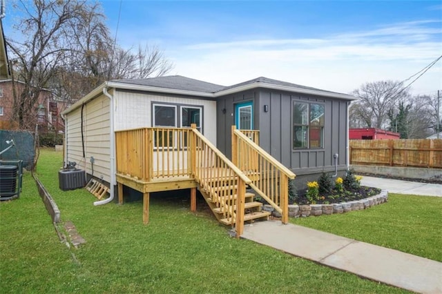 exterior space featuring cooling unit, a front yard, and a deck