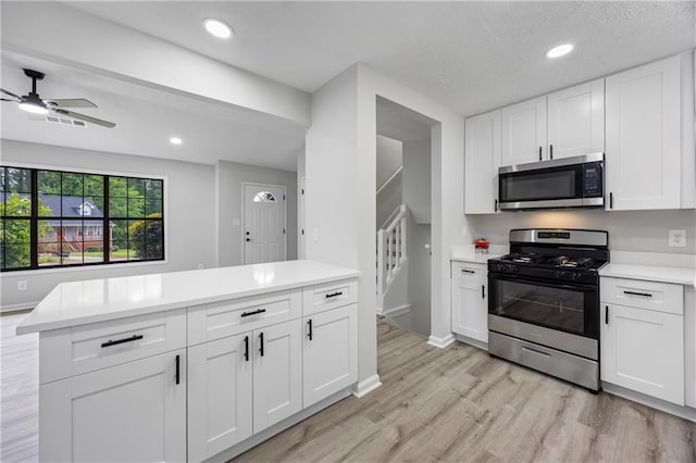 kitchen with light countertops, stainless steel appliances, white cabinetry, and light wood-type flooring