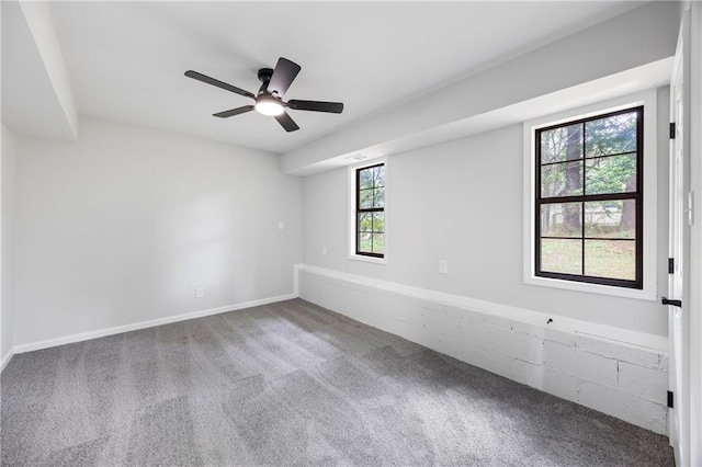 carpeted spare room featuring a ceiling fan