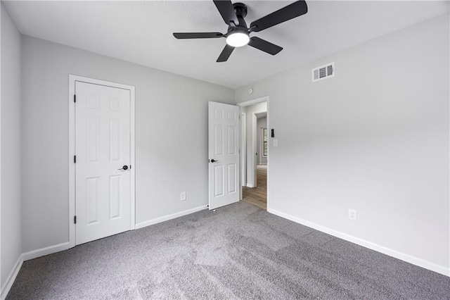 unfurnished bedroom featuring carpet floors, baseboards, visible vents, and ceiling fan