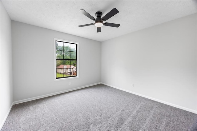 unfurnished room with carpet floors, a textured ceiling, ceiling fan, and baseboards