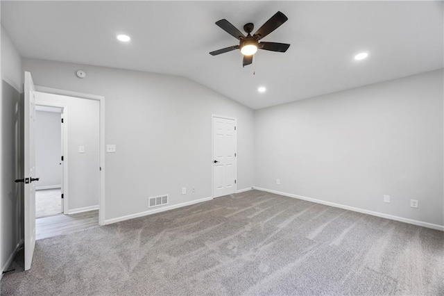carpeted spare room featuring visible vents, baseboards, ceiling fan, recessed lighting, and vaulted ceiling