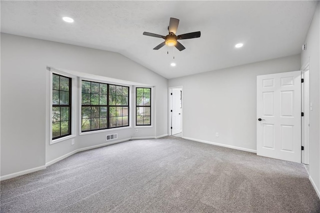 empty room with a ceiling fan, baseboards, visible vents, and lofted ceiling