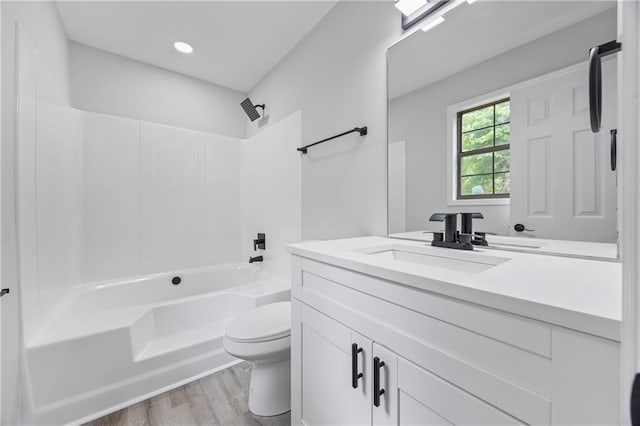 full bathroom featuring wood finished floors, vanity, toilet, recessed lighting, and tub / shower combination