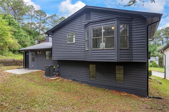 view of side of home with a lawn and central AC unit