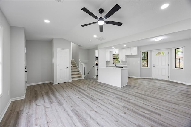 unfurnished living room featuring light wood-style floors, vaulted ceiling, and recessed lighting