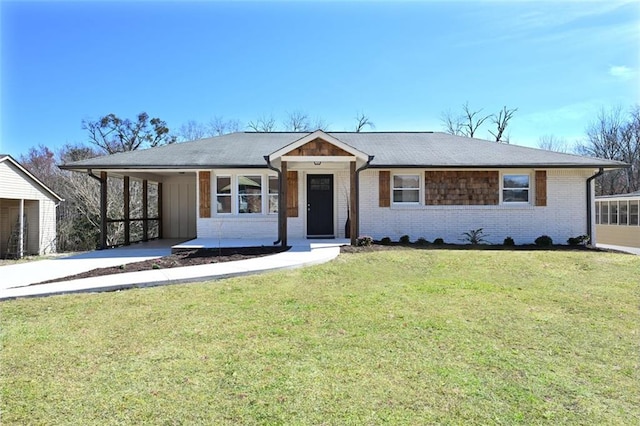 single story home featuring a front yard, a carport, brick siding, and driveway