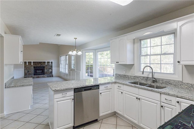 kitchen featuring sink, stainless steel dishwasher, kitchen peninsula, pendant lighting, and white cabinets