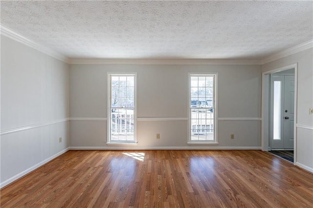 spare room with wood-type flooring, a wealth of natural light, and a textured ceiling