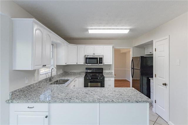 kitchen featuring white cabinetry, sink, kitchen peninsula, and black appliances