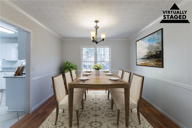 dining area featuring an inviting chandelier, crown molding, and hardwood / wood-style flooring