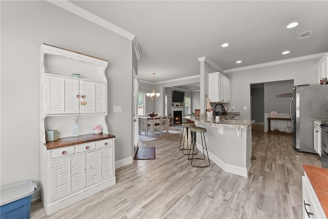 4381 Highland Gate Parkway, Gainesville, GA 30506 - kitchen featuring crown molding, freestanding refrigerator, light wood-style floors, and a kitchen bar