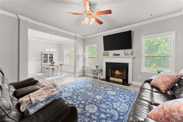 4381 Highland Gate Parkway, Gainesville, GA 30506 - living room featuring a lit fireplace, ornamental molding, wood finished floors, and ceiling fan with notable chandelier