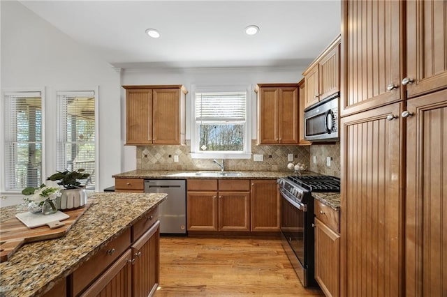 224 Celestial Ridge Dr, Dallas, GA 30132 - kitchen with appliances with stainless steel finishes, light wood-style flooring, backsplash, light stone countertops, and recessed lighting