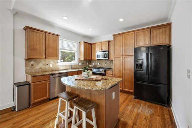 224 Celestial Ridge Dr, Dallas, GA 30132 - kitchen with stainless steel appliances, light wood-style flooring, tasteful backsplash, light stone counters, and a center island