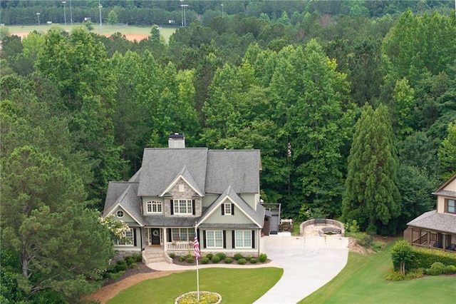 224 Celestial Ridge Dr, Dallas, GA 30132 - view of front of home featuring covered porch, concrete driveway, a front lawn, and a forest view