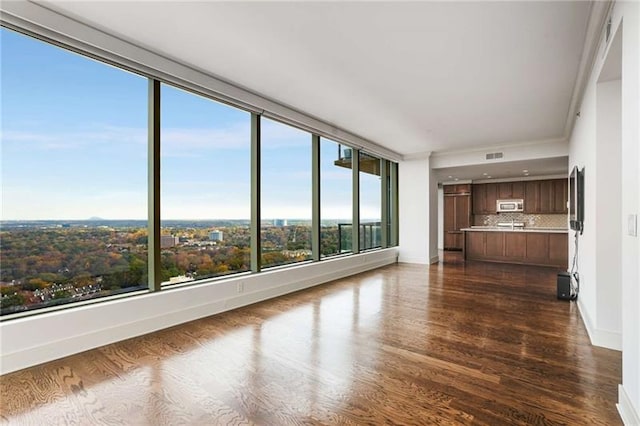 unfurnished living room with dark hardwood / wood-style flooring and a wealth of natural light