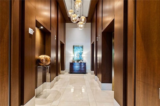 hallway featuring a high ceiling and an inviting chandelier