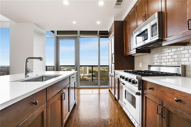 kitchen featuring dark hardwood / wood-style flooring, sink, appliances with stainless steel finishes, and tasteful backsplash