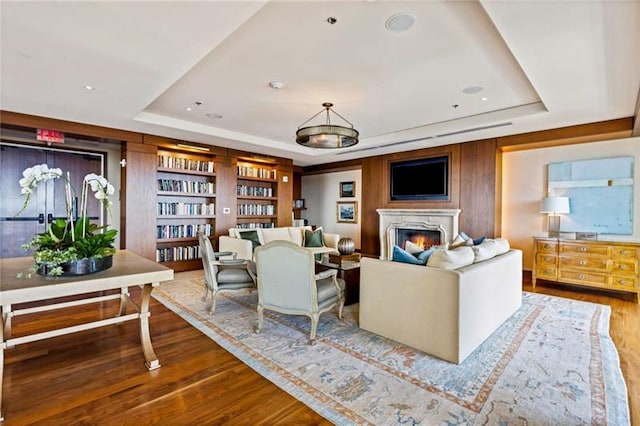 living room with a tray ceiling and hardwood / wood-style floors