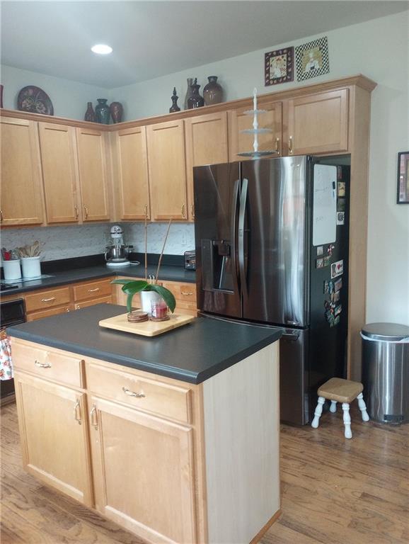102 Ozark Trl, Canton, GA 30114 - kitchen with dark countertops, fridge with ice dispenser, light brown cabinets, and light wood finished floors