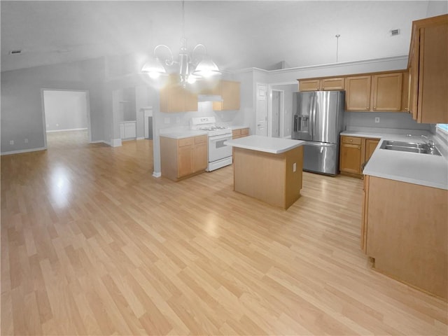 kitchen with stainless steel fridge with ice dispenser, a kitchen island, gas range gas stove, light countertops, and a sink