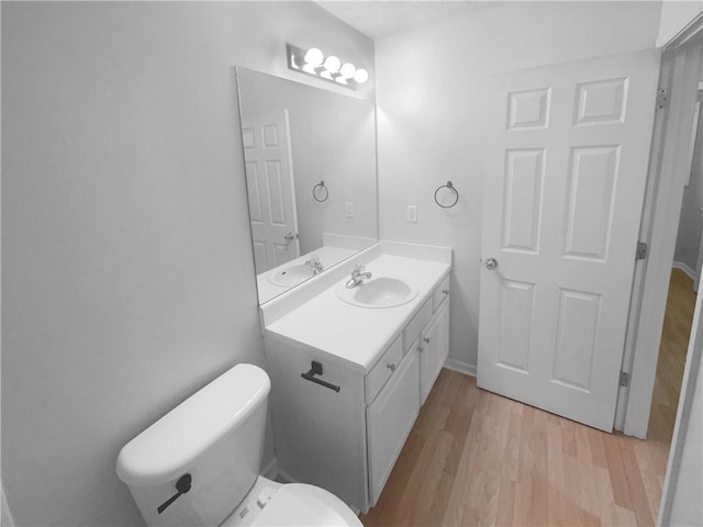 bathroom with vanity, toilet, and wood finished floors