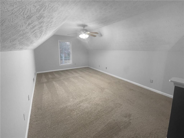 bonus room featuring a textured ceiling, baseboards, vaulted ceiling, and carpet flooring