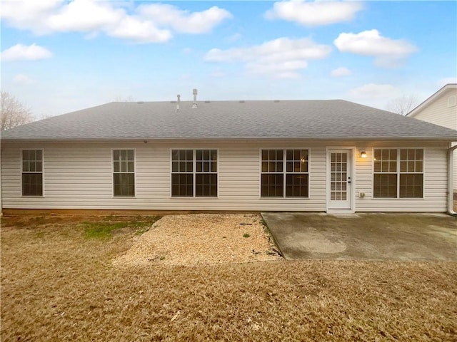 rear view of property with a patio area, a shingled roof, and a yard