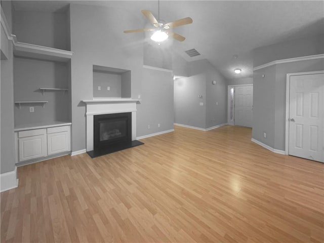 unfurnished living room featuring light wood finished floors, a glass covered fireplace, visible vents, and baseboards