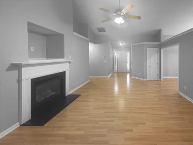 unfurnished living room featuring a fireplace with raised hearth, a ceiling fan, baseboards, visible vents, and light wood-style floors