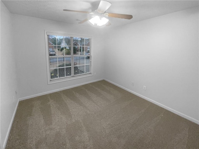 carpeted empty room with ceiling fan and baseboards