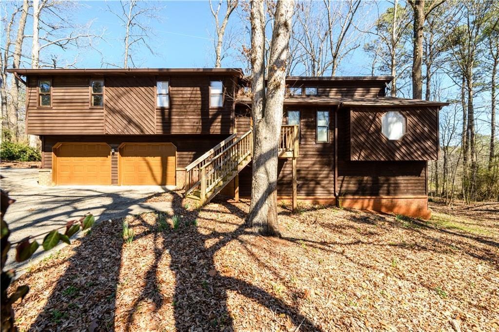 view of front of property with stairway, a garage, and driveway