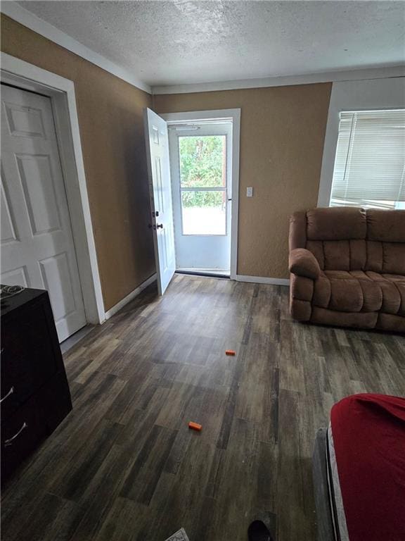 doorway to outside with dark hardwood / wood-style floors and a textured ceiling