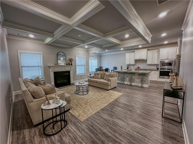 living room with hardwood / wood-style floors, beam ceiling, ornamental molding, and coffered ceiling