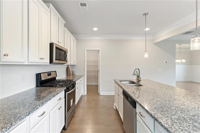5103 Woodline View Ln, Auburn, GA 30011 - kitchen with stainless steel appliances, a sink, ornamental molding, white cabinets, and decorative backsplash