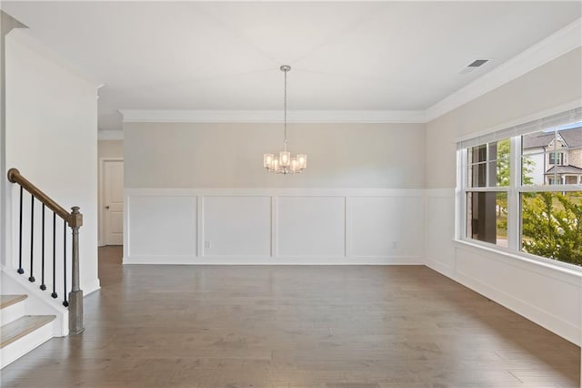 5103 Woodline View Ln, Auburn, GA 30011 - unfurnished dining area with a chandelier, crown molding, a decorative wall, wood finished floors, and a wainscoted wall