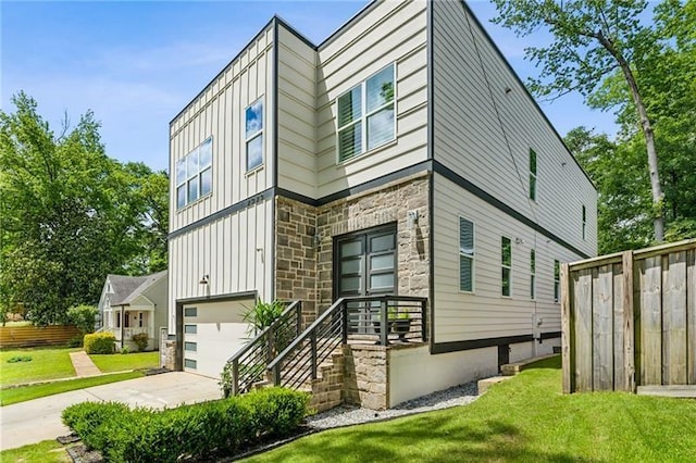 2020 Bixby St SE, Atlanta, GA 30317 - view of property exterior with board and batten siding, stone siding, a garage, and driveway