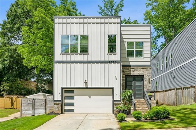 2020 Bixby St SE, Atlanta, GA 30317 - view of front facade with board and batten siding, stone siding, an attached garage, and driveway