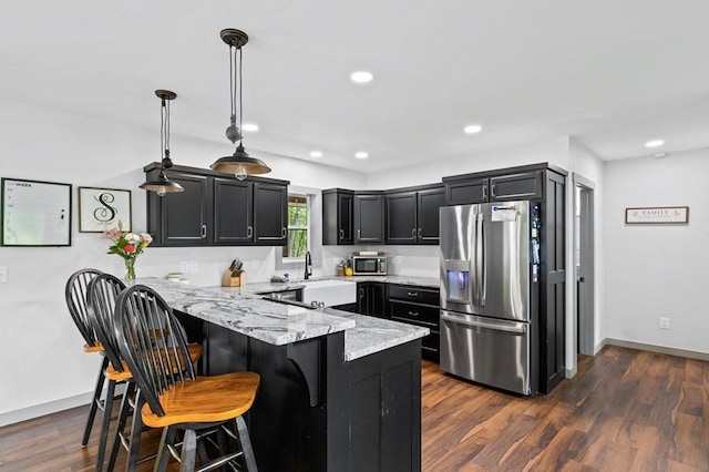 35 Indian Trce, Mineral Bluff, GA 30559 - kitchen featuring stainless steel appliances, a peninsula, light stone countertops, a breakfast bar area, and dark cabinetry