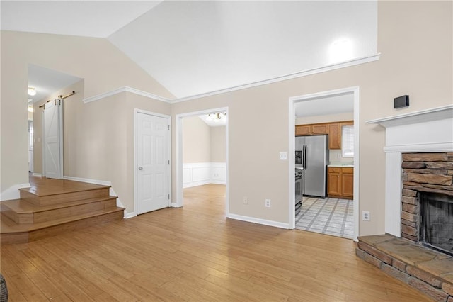 unfurnished living room with a fireplace, stairway, light wood-style floors, and high vaulted ceiling