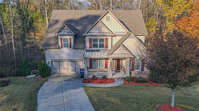 view of front of house with a porch, a garage, and a front lawn